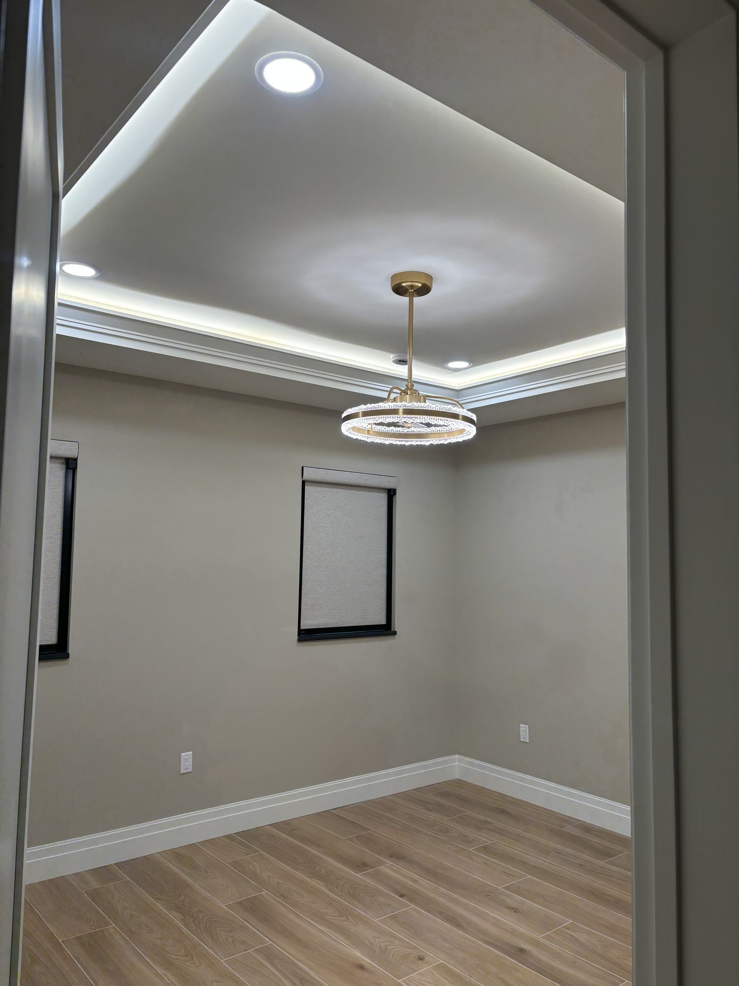 Bedroom tray ceiling with cove LED lighting and ring pendant fixture in Tampa waterfront home by Dim and Dimmer Electric