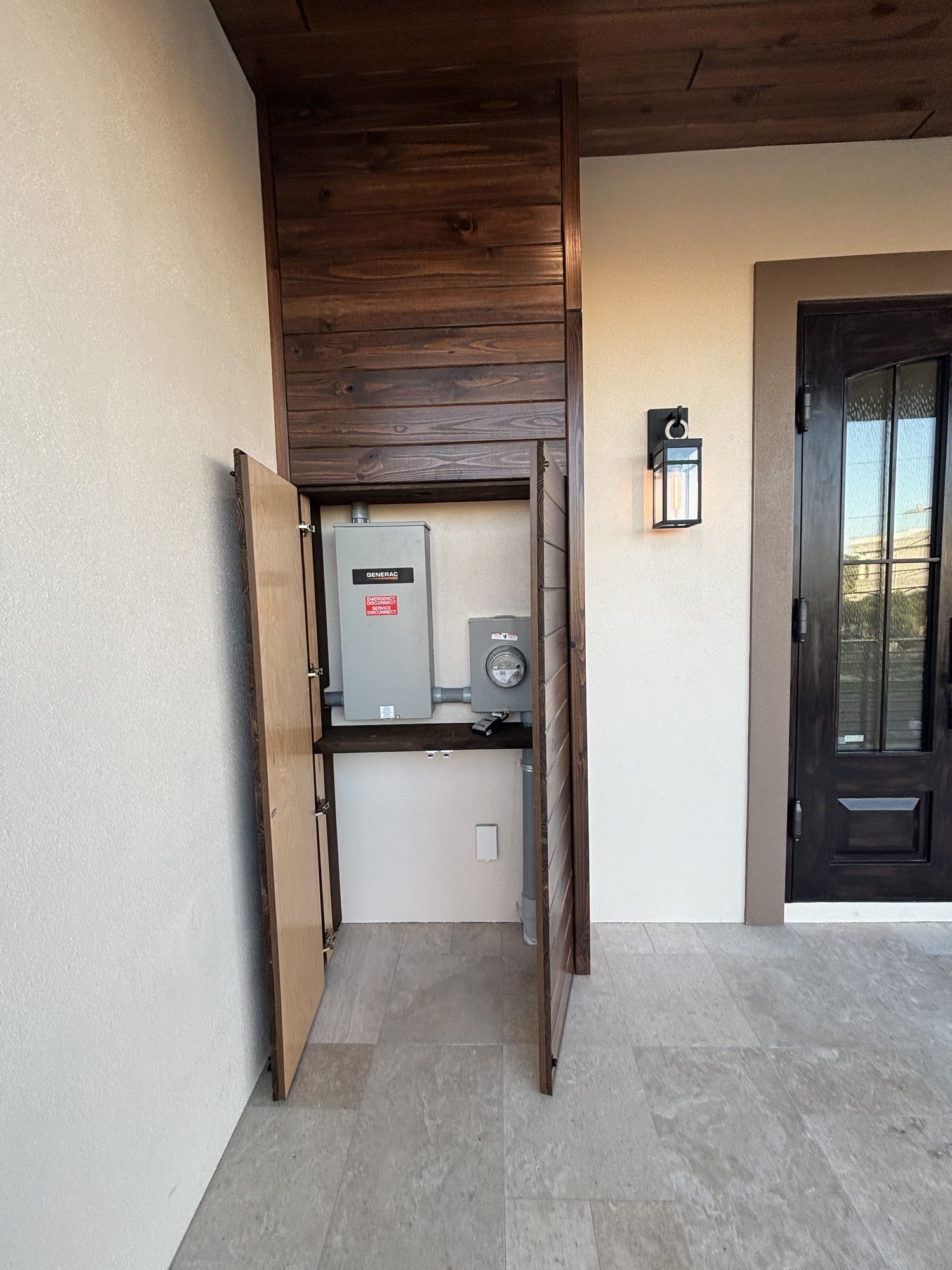 Main electrical panel concealed behind custom wood panel door in Tampa custom home by Dim and Dimmer Electric