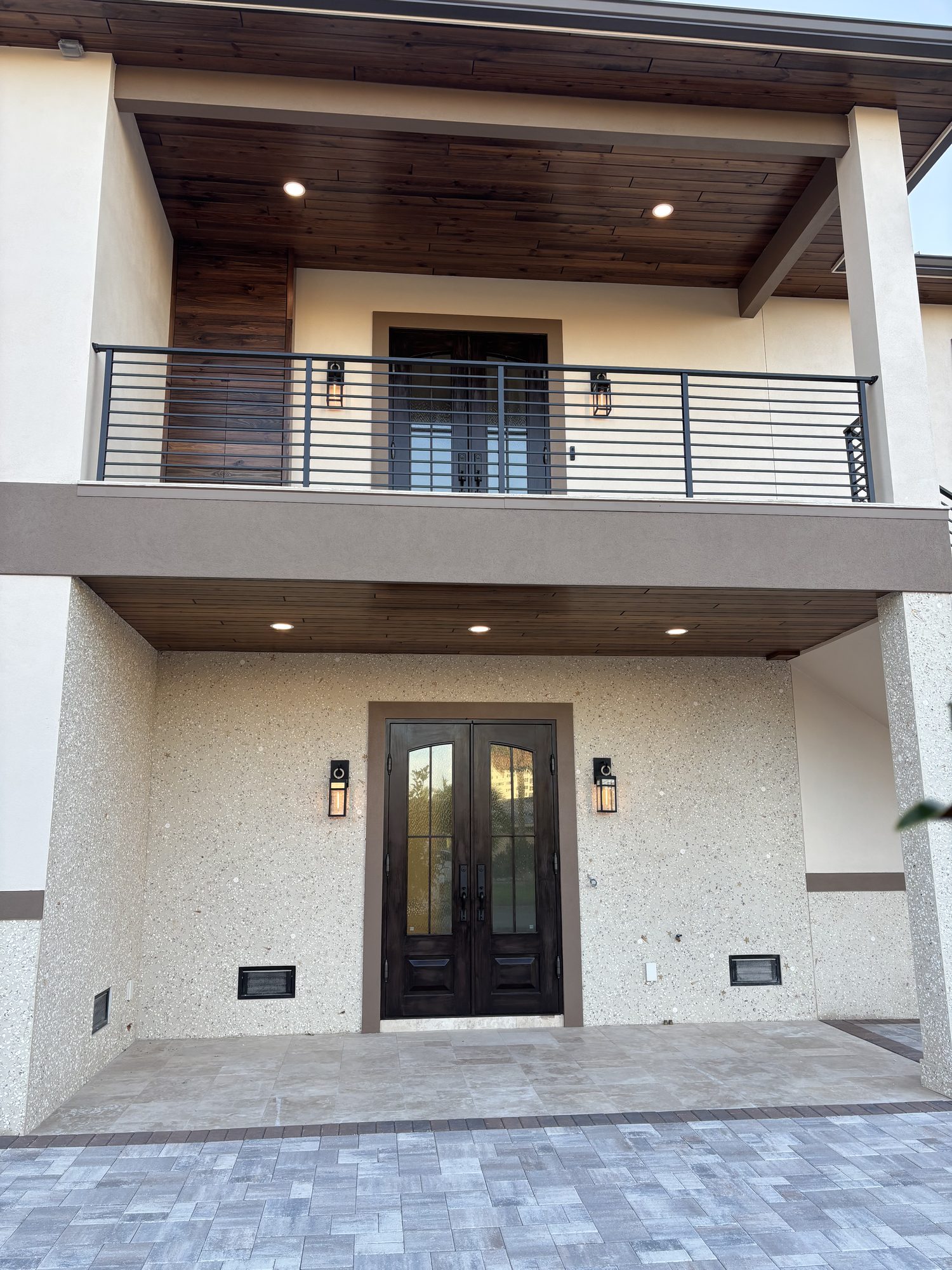 Front entry exterior with sconce and soffit recessed lighting on Tampa waterfront custom home by Dim and Dimmer Electric